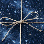 Close-up of a gift wrapped in elegant blue floral wrapping paper with a rustic twine bow.