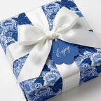 Luxury blue floral wrapping paper with a white satin bow and 'Enjoy' gift tag by Wrapped Studios.