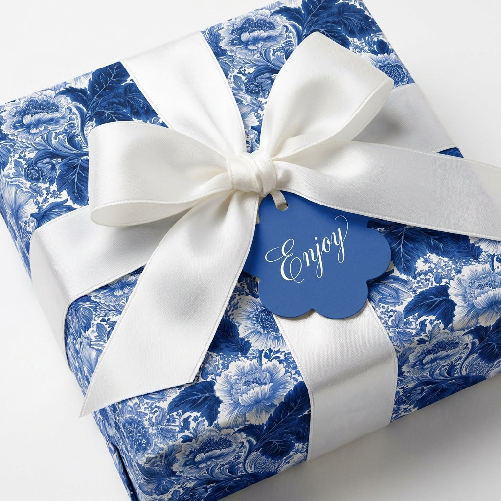 Luxury blue floral wrapping paper with a white satin bow and 'Enjoy' gift tag by Wrapped Studios.