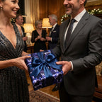 Couple exchanging a holiday gift in luxury blue Christmas wrapping paper by Wrapped Studios.