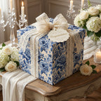 Elegant gift wrapped in blue floral wrapping paper, with a lace bow and trim.