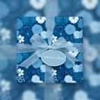 Elegant blue floral wrapping paper on square gift box with sheer ribbon and "With Love, Always" tag.