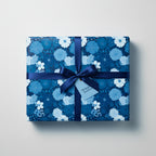 Elegant blue floral wrapping paper with satin ribbon on a square gift box.