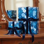 Elegant gifts wrapped in blue floral wrapping paper with velvet ribbon bows.
