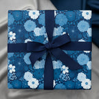 Square gift wrapped in blue floral wrapping paper with navy ribbon.