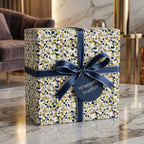 Luxury gift box in gold, blue, and white terrazzo wrapping paper with a navy satin ribbon, by Wrapped Studios.