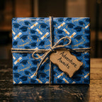 Blue congrats graduation wrapping paper by Wrapped Studios, tied with twine on a rustic gift box.