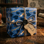 Blue graduation wrapping paper with caps and diplomas, tied with rustic twine, by Wrapped Studios.
