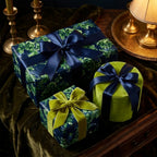 Luxury green floral wrapping paper with navy satin bows on elegant holiday gifts by Wrapped Studios.