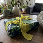 Luxury dark floral wrapping paper with green botanical print and chartreuse ribbon by Wrapped Studios.