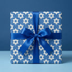 Blue Star of David Hanukkah wrapping paper with matching satin bow on a gift box, by Wrapped Studios.