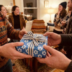 Blue Star of David Hanukkah wrapping paper with striped ribbon by Wrapped Studios at a festive gift exchange.