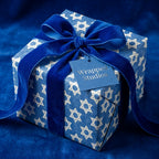 Hanukkah wrapping paper with Star of David pattern and luxury blue velvet ribbon by Wrapped Studios.