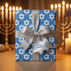 Blue Star of David Hanukkah wrapping paper with silver bow and menorah background by Wrapped Studios.