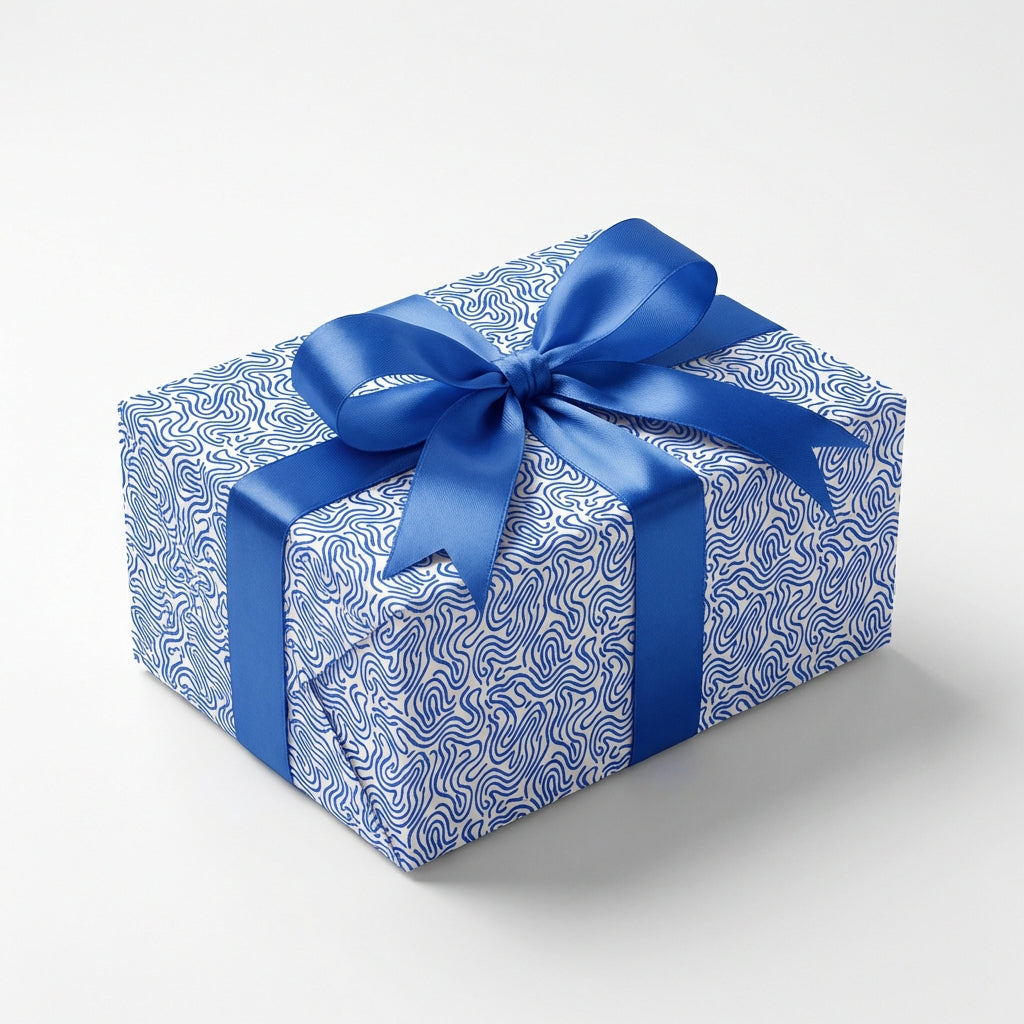 Modern blue and white wavy pattern wrapping paper on a gift box, tied with an elegant royal blue satin ribbon bow.