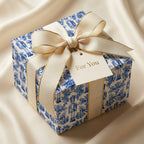 Blue and white toile nutcracker Christmas wrapping paper with cream bow by Wrapped Studios.