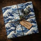 Gift wrapped in blue wave patterned paper with 'Adventure Awaits' tag on wooden surface