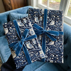 Two gifts wrapped in navy owl-print paper with blue velvet ribbon from Wrapped Studios.