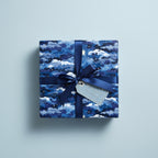 Square gift wrapped in blue night sky wrapping paper with a matching bow.