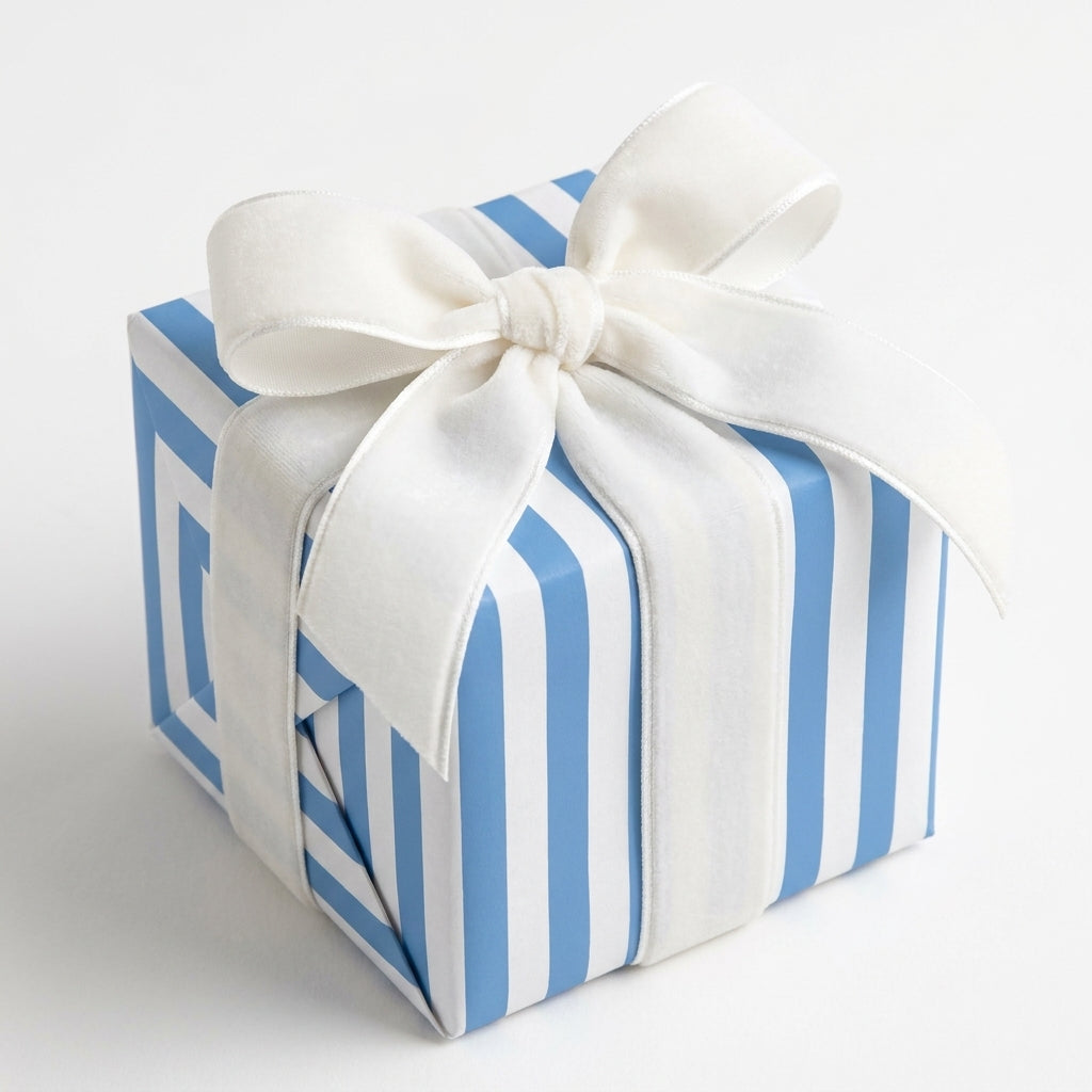 Blue and white striped wrapping paper with a white velvet bow for baby shower gifts, by Wrapped Studios.