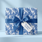 Vintage blue toile wrapping paper on a gift box with a satin bow, by Wrapped Studios.