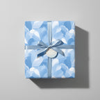 Sky-blue floral wrapping paper on a gift box with matching ribbon and tag; perfect for birthdays or baby showers.