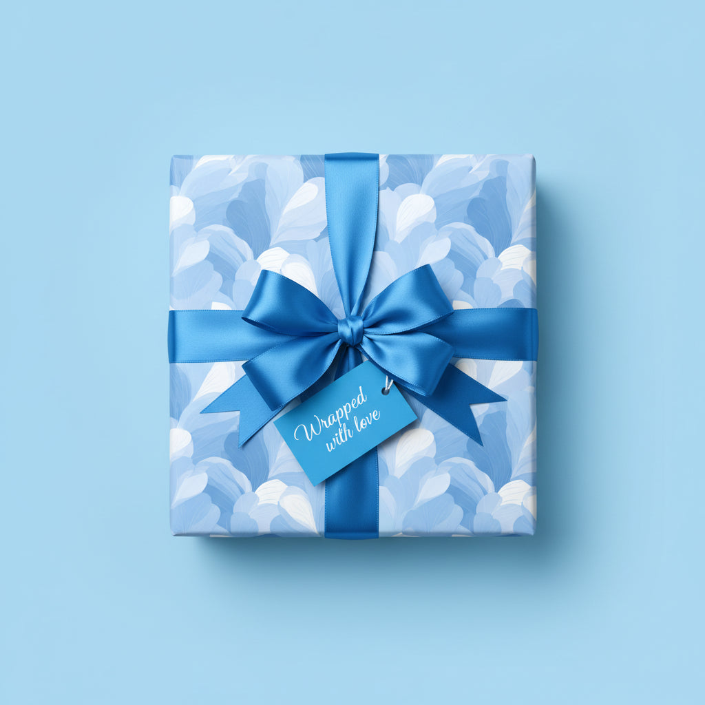 Square gift box wrapped in blue floral wrapping paper with satin bow and "Wrapped with love" tag.
