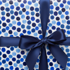 Navy blue ribbon on gift wrapped in watercolor polka dot wrapping paper.