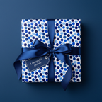 Square gift wrapped in blue polka dot wrapping paper with blue satin ribbon and tag.