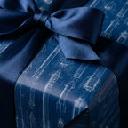 Navy blue rocket blueprint wrapping paper with a matching satin bow by Wrapped Studios.