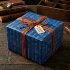 Rocket blueprint wrapping paper by Wrapped Studios on a gift box tied with orange twine ribbon.