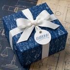 Navy blue science wrapping paper with chemistry blueprint pattern and white bow by Wrapped Studios.