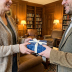Blue science wrapping paper with a white bow on a gift exchanged in a cozy library by Wrapped Studios.