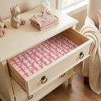 Pink teddy bear baby shower wrapping paper lining a nursery dresser drawer, by Wrapped Studios.