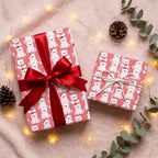 Pink polar bear Christmas wrapping paper with red satin ribbon on cozy holiday gifts by Wrapped Studios.