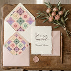 Elegant pastel mandala envelope liners and wedding invitation on rustic wood by Wrapped Studios.