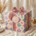 Vintage floral wrapping paper in a pastel mosaic pattern with a pink velvet bow, by Wrapped Studios.