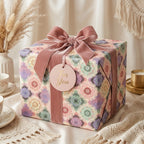 Vintage floral wrapping paper in a pastel mosaic pattern with a pink velvet bow, by Wrapped Studios.