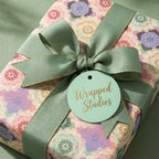 Elegant pastel mandala wrapping paper with a sage green bow by Wrapped Studios.