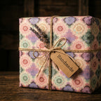 Boho floral wrapping paper with twine, lavender, and a handmade tag on a rustic gift by Wrapped Studios.
