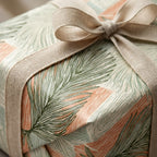 Sage green botanical wrapping paper with peach leaves and linen ribbon bow by Wrapped Studios.
