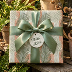 Luxury botanical wrapping paper with sage green leaves, terracotta stripes, and satin bow by Wrapped Studios.