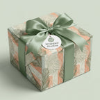 Botanical sage green and peach wrapping paper with a satin ribbon bow, luxury gift wrap by Wrapped Studios.