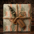 Rustic botanical Christmas wrapping paper with pine pattern and twine bow by Wrapped Studios.