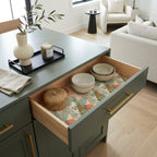 Sage green and terracotta botanical wrapping paper lining a cabinet drawer by Wrapped Studios.