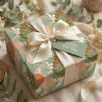 Sage green ginkgo botanical wrapping paper with a cream ribbon on a gift box by Wrapped Studios.