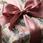 Luxury floral wrapping paper with a dusty rose satin bow by Wrapped Studios.