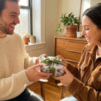 Couple exchanging a gift in luxury floral wrapping paper with green ribbon by Wrapped Studios.