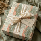 Boho palm leaf wrapping paper with cream ribbon and 'With Love' tag by Wrapped Studios.