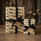 Crocodile birthday wrapping paper with black ribbons and Wild & Free tags by Wrapped Studios.